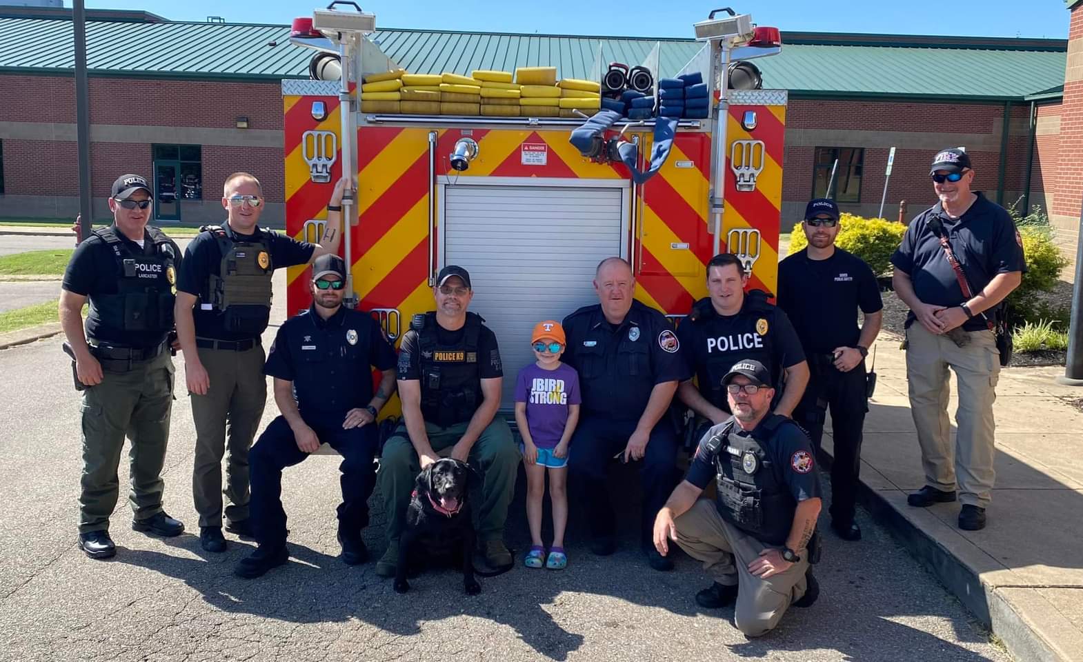 Public safety personnel gathered in front of apparatus